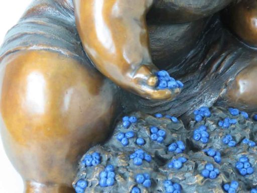 Détail 01 de la sculpture de bronze d'une femme cueillant des bleuets par Rose-Aimée Bélanger à vendre en galerie d'art à Montréal. « Bleuets sur la colline » disponible à la Galerie Blanche.